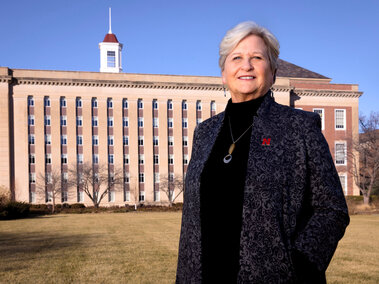 Katherine Ankerson wearing gray jacquard jacket standing outside Love Library